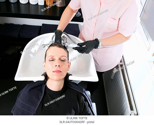 Hairdresser washing woman?s hair