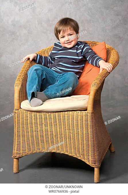 Little boy sitting in an armchair
