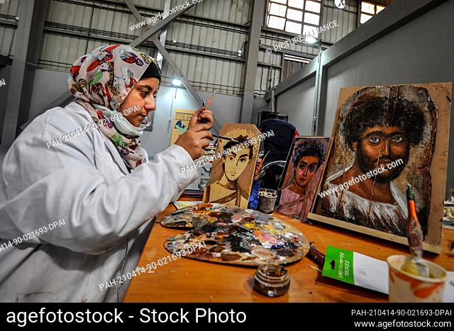 13 April 2021, Egypt, Obour City: An artist works on painting model replicas of the ancient Egyptian Fayum mummy portraits, at Konouz factory