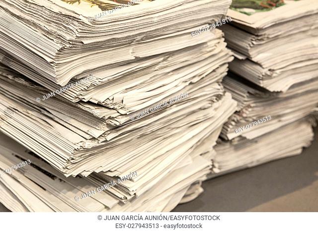 Two huge pile of many newspapers over floor