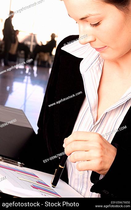Businesswoman reads financial report in the lobby