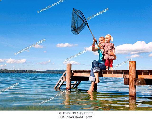 Mother and daughter fishing with net