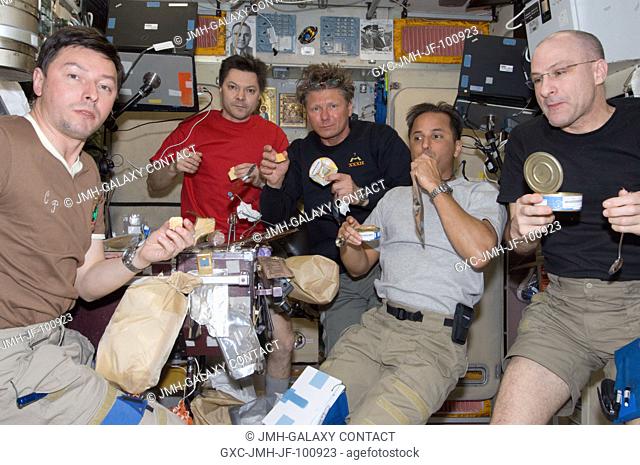 Expedition 31 crew members share a meal near the galley in the Zvezda Service Module of the International Space Station. Pictured from the left are Russian...