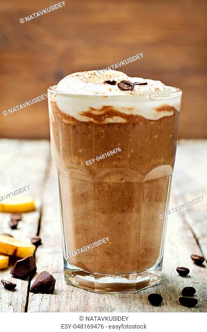 coffee chocolate banana smoothie with coconut whipped cream. toning. selective focus