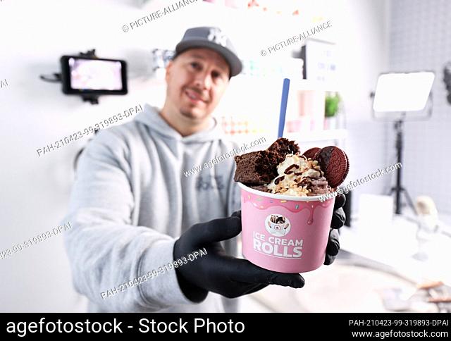 19 April 2021, Hamburg: Gil Grobe, Youtuber, holds a Brownie & Oreo ice cream creation in his studio. With his unusual ice cream creations on the Youtube...