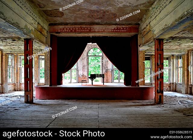Blick in den Musik- und Theatersaal mit Buehne und Vorhang einer laengst verlassenen Heilstaette in der Berliner Peripherie