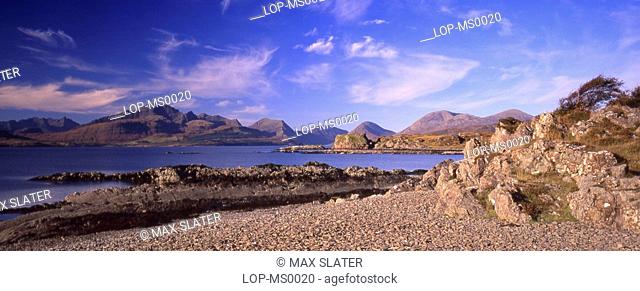 Scotland, Isle of Skye, Sleat, Panoramic view of mountains with beach and rocky coastline in foreground