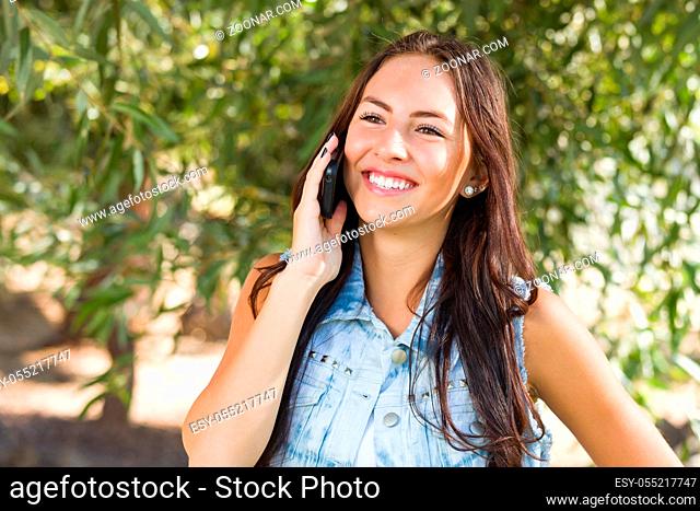 Attractive Happy Mixed Race Young Female Talking on Cell Phone Outside