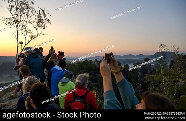 22 September 2020, Saxony, Rathen: In the early morning, numerous tourists stand on a viewing platform in the Saxon Switzerland National Park in front of the...