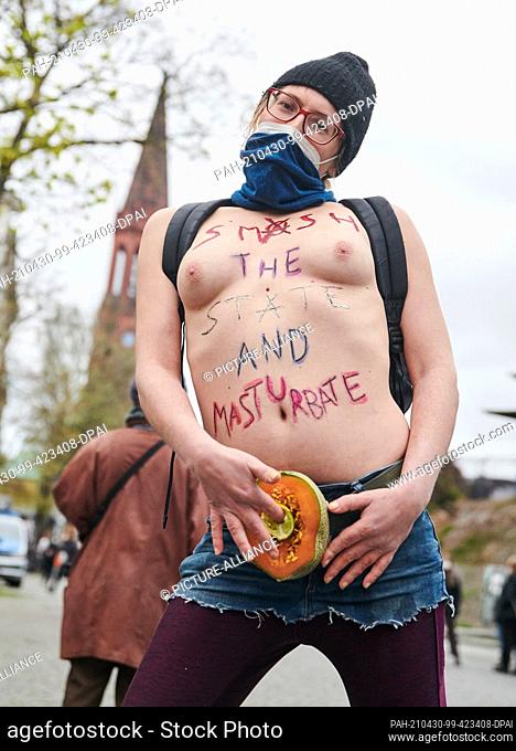 30 April 2021, Berlin: ""Smash the State and Masturbate"" is written on the naked torso of a demonstrator. ""Take back the night"" is the motto of the...