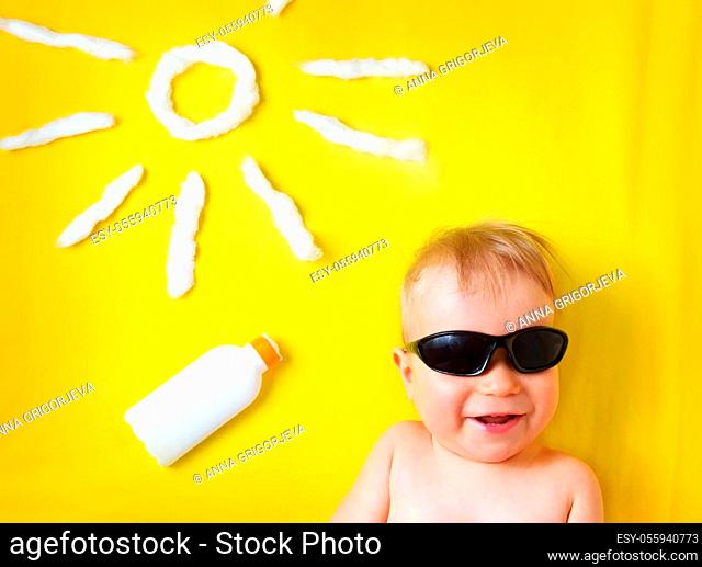 little boy with sunglasses and sun shape on yellow blanket