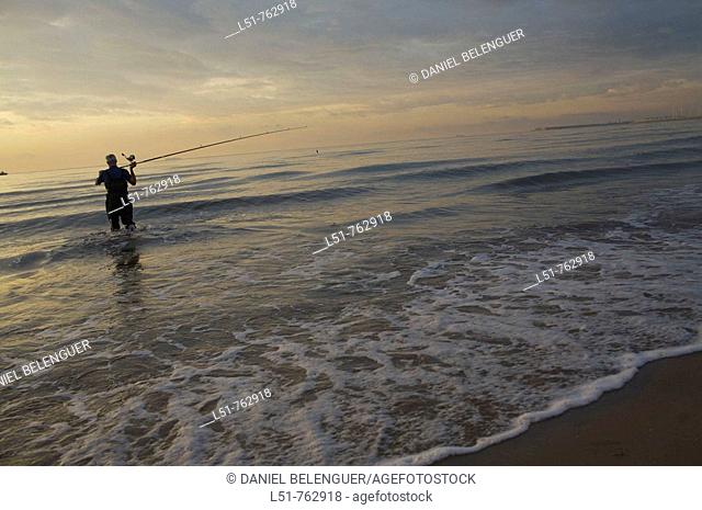 Man fishing at sunrise on Malvarrosa beach, Valencia city, Valencia, Comunidad Valenciana, Spain, Europe