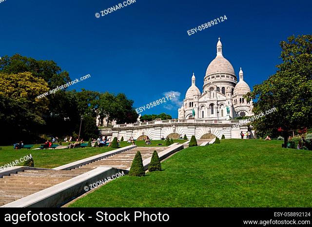 PARIS - SEPT 16, 2014: Tourists near the Basilica of the Sacred Heart of Paris or Sacre-Coeur is a Roman Catholic church