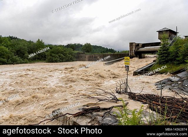 High water at the hydropower plant in Krün on the Isar River in the Bavarian Alps. The brown water flows through the plant