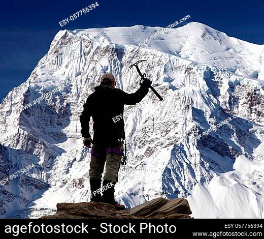 View of south rock face of mount Annapurna 3 III, Annapurna range and hiker, Annapurna circuit trekking trail, Nepal