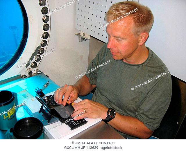 NEEMO 11 astronautaquanaut Timothy L. Kopra uses a computer inside the undersea habitat for the NASA Extreme Environment Mission Operations (NEEMO) project