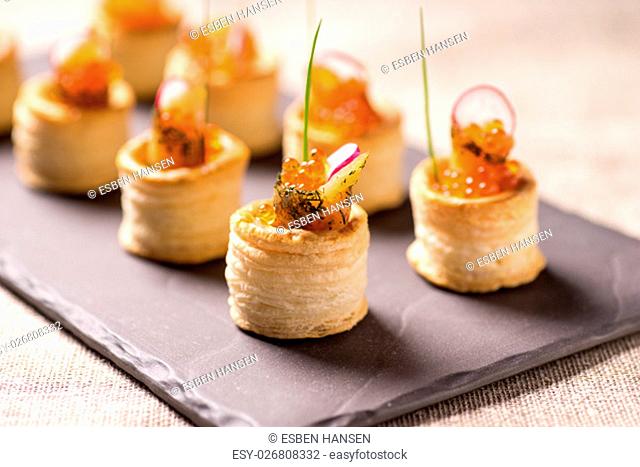 Delicious appetizers with graved salmon and golden caviar served in puff pastry towers