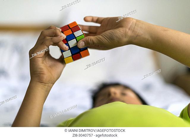 Boy plays with Rubic Cube, UK