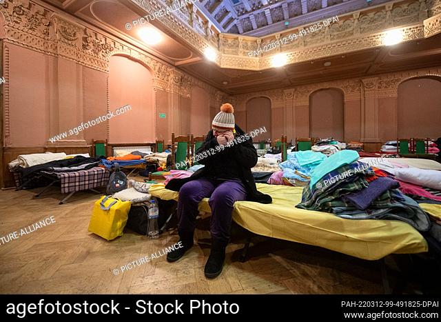 12 March 2022, Poland, Przemysl: Yulia Steblena, who fled Zaporizhzhya in Ukraine, is standing with her luggage in the theater hall of the Ukrainian company