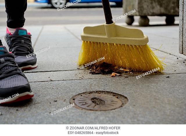 Straßenfeger reinigt mit Kehrbesen die Strasse - Nahaufnahme