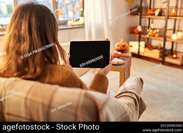 woman with tablet pc at home on halloween