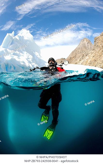 Diver in front of an iceberg, Astrolabe Island, Antarctic peninsula