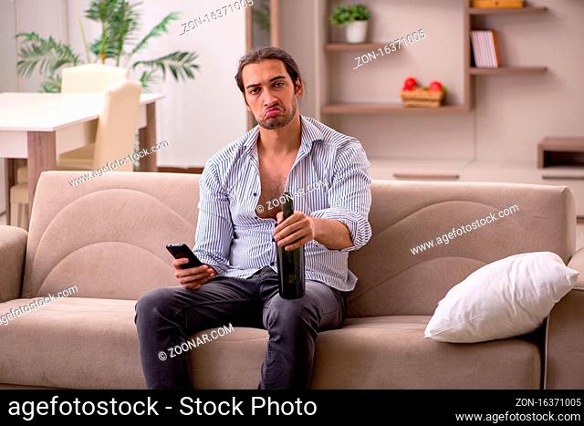 Young drunken man suffering at home