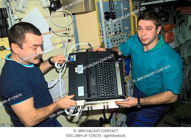 Cosmonaut Mikhail Tyurin (left), Expedition Three flight engineer, and Soyuz Taxi crewmember, Flight Engineer Konstantin Kozeev work in the Zvezda Service...