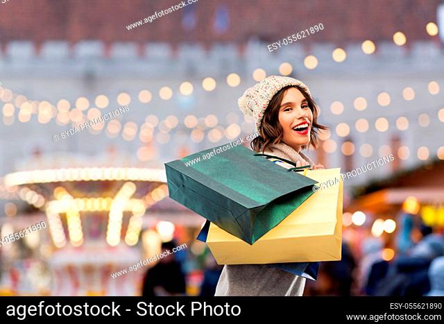 happy woman with shopping bags at christmas market