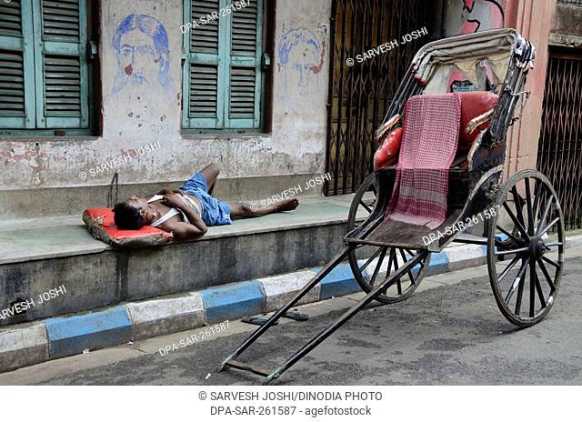 hand rickshaw puller sleeping on footpath, Kolkata, West Bengal, India, Asia