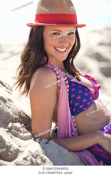 Smiling woman wearing sun hat on beach