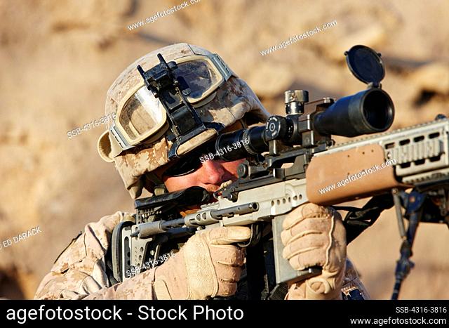 A U.S. Marine Aims a Rifle During a Combat Operation Outside the City of Marjah, Helmand Province of Afghanistan