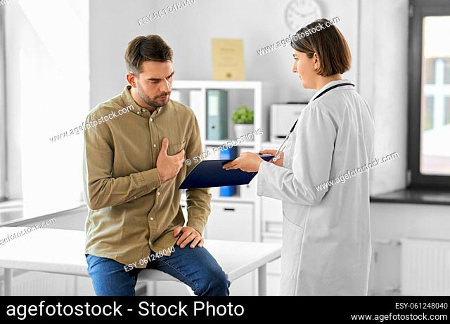 doctor showing clipboard to male patient at clinic
