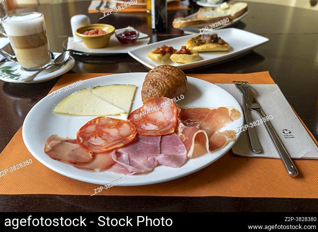 Spanish breakfast in hotel table. Chorizo serrano ham manchego cheese and croissant
