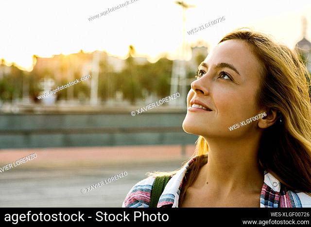 Beautiful blond woman looking up during sunset