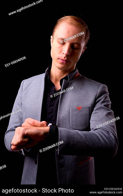 Studio shot of businessman with blond hair against black background