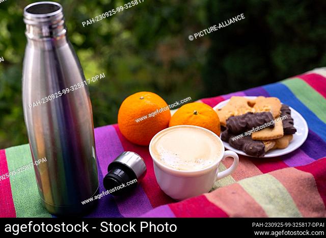 ILLUSTRATION - 18 September 2023, Berlin: An open thermos is on a picnic blanket next to oranges and cookies. Photo: Monika Skolimowska/dpa