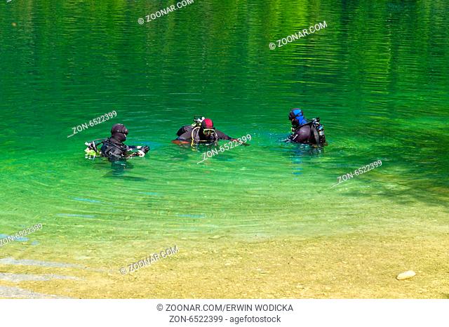 In einem See machen sich Taucher bereit zu einem Tauchgang. Österreich, Oberösterreich, Langbathsee