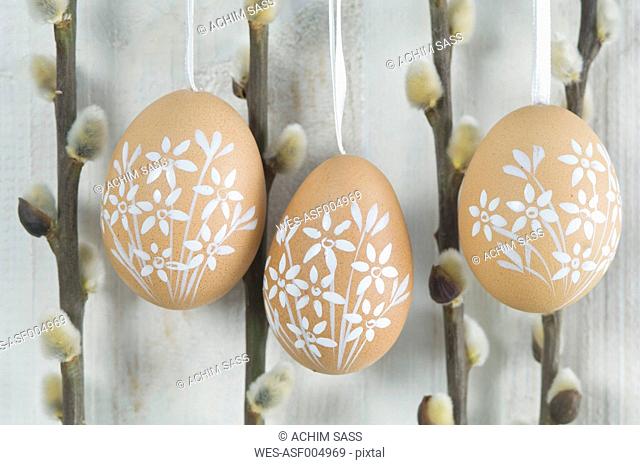 Painted easter eggs hanging on wooden wall