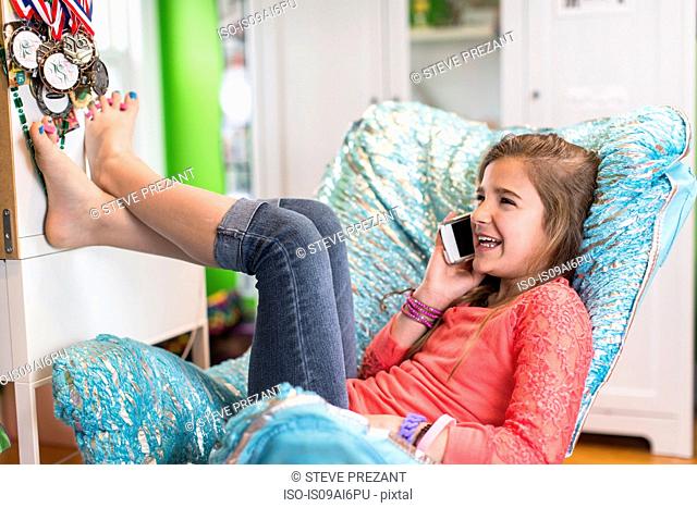 Girl sitting on armchair on phonecall