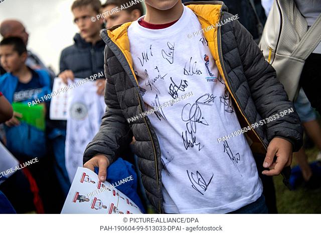04 June 2019, France (France), Pont-Péan: Football, women, national team: training before the World Cup in France. A boy wears a T-shirt with the team's...