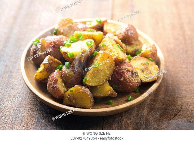 Freshly oven roasted delicious baby potatoes on wooden table