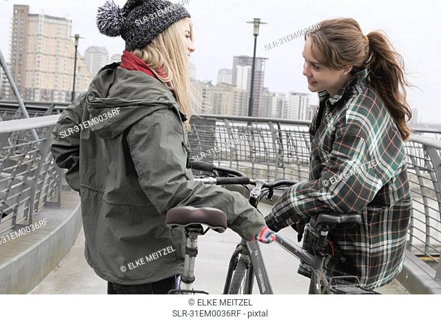 2 young women chatting with push bikes