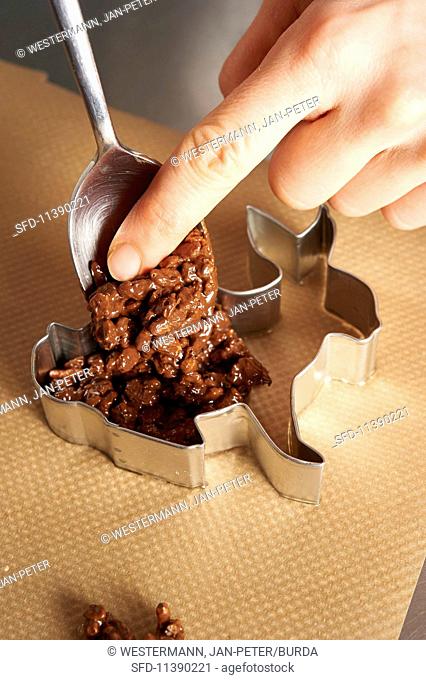 A crispy bunny being made: chocolate rice crispy mixture being placed in a mould