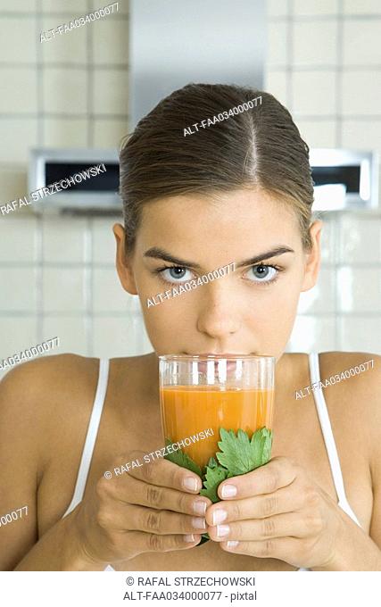 Woman with glass of fresh carrot juice