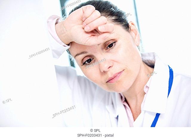 Young female medical student with head in hands