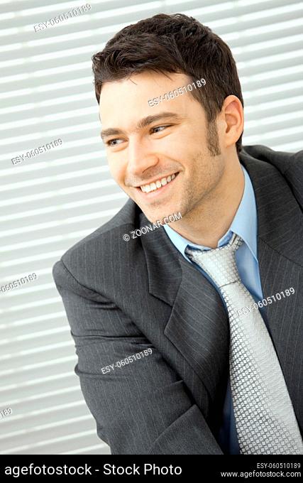 Portrait of happy young businessman at office, smiling