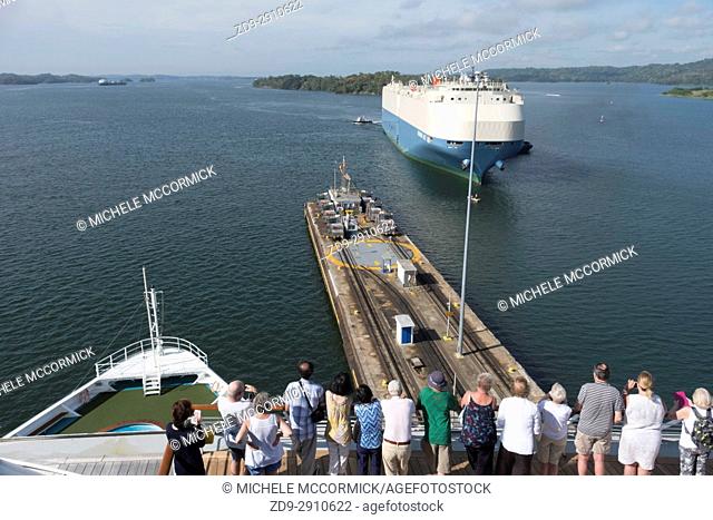 Tourists watch as a ship approaches a lock in the Panama Canal
