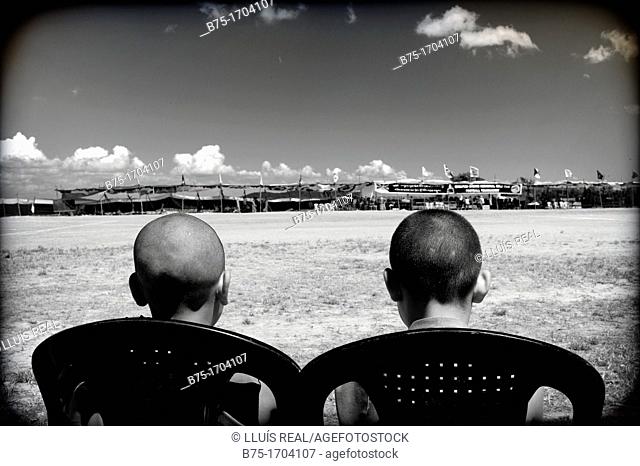 Dos jovenes sentados de espaldas mirando un partido de futbol en Mundgod, Karnataka, India, Asia, Two young men sitting back watching a football match in...