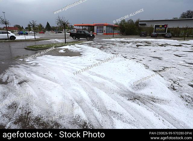 26 August 2023, Bavaria, Kissing: The parking lot of a supermarket is covered with hail. The German Weather Service (DWD) continued to warn of severe weather in...